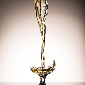 liquid pouring on clear short-stem wine glass